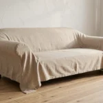 Housse en lin beige ajustée sur un canapé méridienne dans un salon scandinave moderne