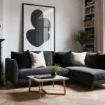 Salon glamour noir et blanc avec canapé velours anthracite, table basse en laiton doré et miroir noir encadré sur mur blanc
