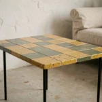 Table basse Capron en céramique émaillée aux carreaux moutarde et vert olive dans un salon minimaliste vintage