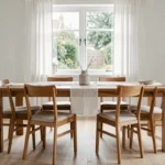 Table et chaises en teck massif dans une salle à manger scandinave lumineuse avec parquet clair et décoration minimaliste